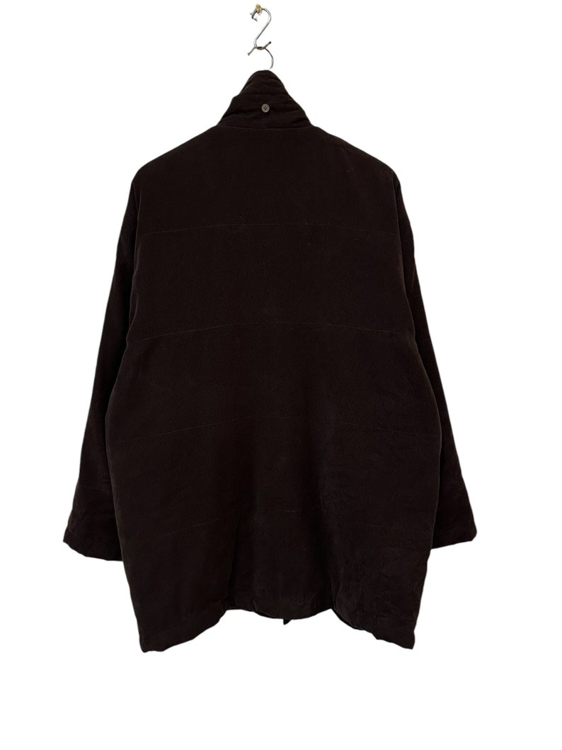 May include: A dark brown quilted jacket with a high collar and a zip closure.