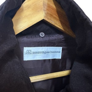 May include: A black corduroy jacket with a zip fastening and a label that reads "courr&egrave;ges homme" on the inside.