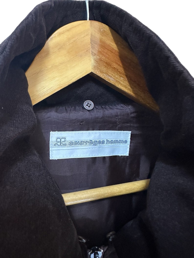 May include: A black corduroy jacket with a zip fastening and a label that reads "courr&egrave;ges homme" on the inside.