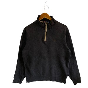 May include: A dark gray 1/4 zip pullover sweatshirt with a beige zipper and the word "CHAPS" in white lettering on the collar.