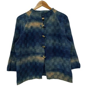 Op de afbeelding: Een blauw en bruin gepatroneerd jack met een mandarijnkraag en knoopsluiting.