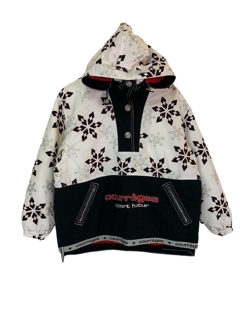 May include: White hooded jacket with a black and white snowflake pattern. The jacket has a black zipper and a black and red logo that says "Courr&egrave;ges Sport Futur".