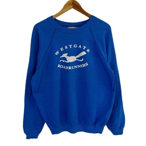 May include: A royal blue sweatshirt with a white embroidered logo that says "Westgate Roadrunners" and features a white silhouette of a roadrunner.