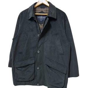 May include: A black long-sleeved jacket with a zip and button fastening. The jacket has two large pockets on the front and a plaid lining on the collar.