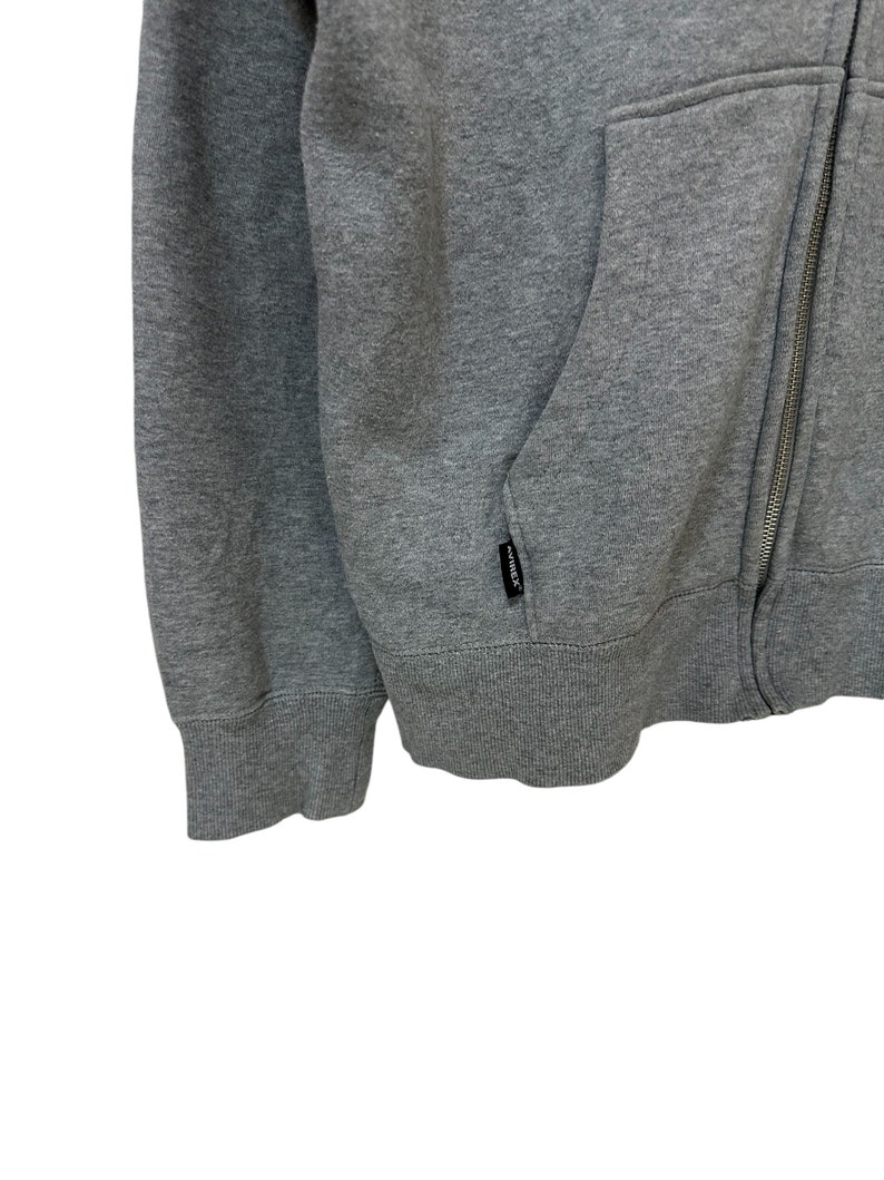 May include: A gray zippered hoodie with a kangaroo pocket and a small black "remark" label on the pocket.