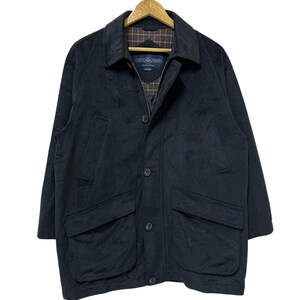 May include: A black corduroy jacket with a button fastening and two large pockets on the front. The jacket has a plaid lining and a label that reads "Country Classics Sportswear".
