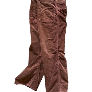 Könnte beinhalten: Eine braune Cordhose, die in der Hälfte gefaltet ist. Die Hose hat einen geraden Schnitt und ist aus einem weichen, bequemen Stoff.