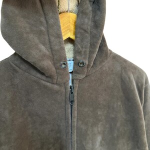 Puede incluir: Una sudadera con capucha de color marr&oacute;n de vell&oacute;n con cierre de cremallera. La sudadera tiene un forro suave y peludo.