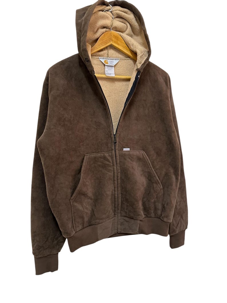 Puede incluir: Una sudadera con capucha marr&oacute;n con cierre de cremallera. La sudadera tiene un forro de polar y un peque&ntilde;o logotipo en el pecho izquierdo.