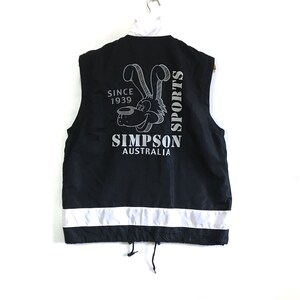Könnte beinhalten: Schwarze ärmellose Weste mit einem weißen reflektierenden Streifen am unteren Rand. Die Weste hat ein Cartoon-Hundelogo mit dem Text "Simpson Australia" und "Sports" auf der Rückseite.