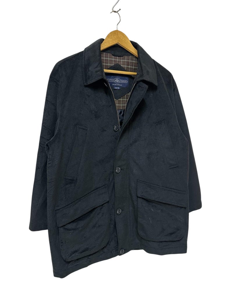 May include: A black jacket with a zip and button fastening. The jacket has two large pockets on the front and a plaid lining.
