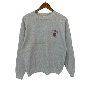 Könnte beinhalten: Ein graues Sweatshirt mit einem roten gestickten Logo, auf dem "USS Fort McHenry LSD 43" steht.