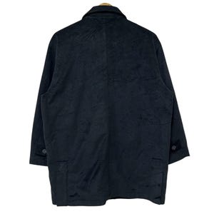 May include: A black long-sleeved jacket with a button-up front and two pockets. The jacket is made of a textured fabric.