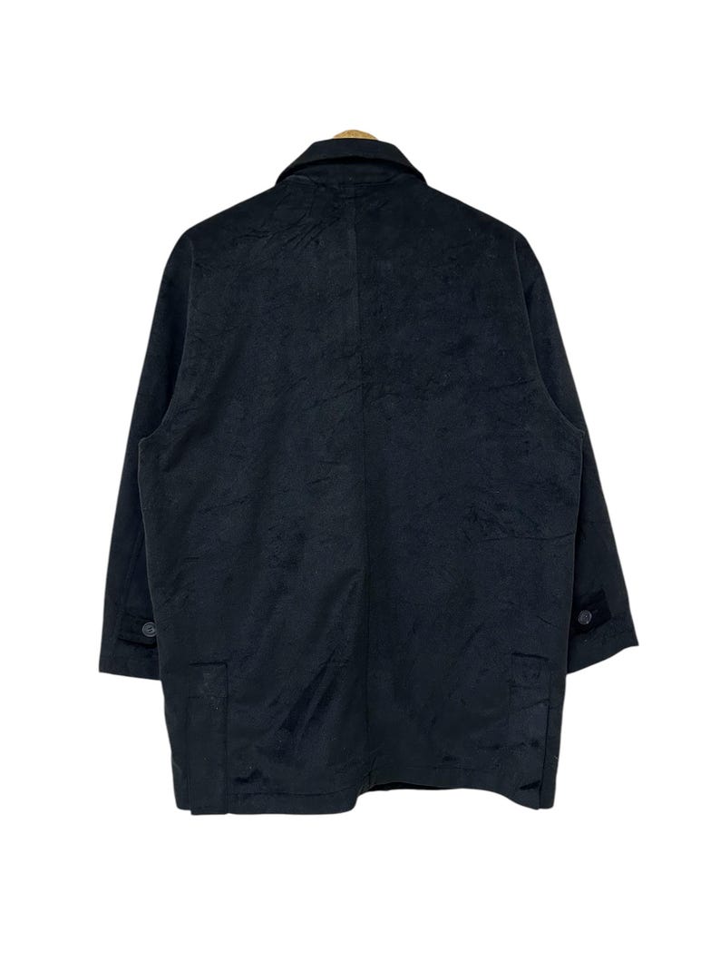 May include: A black long-sleeved jacket with a button-up front and two pockets. The jacket is made of a textured fabric.