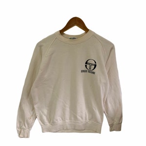 May include: A white sweatshirt with a black Sergio Tacchini logo on the front.