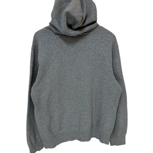 May include: A gray hooded sweatshirt with a high neckline and long sleeves.