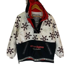 May include: White and black ski jacket with a snowflake pattern. The jacket has a black zipper and a red lining. The text "Courr&egrave;ges Sport Futur" is printed on the front of the jacket.