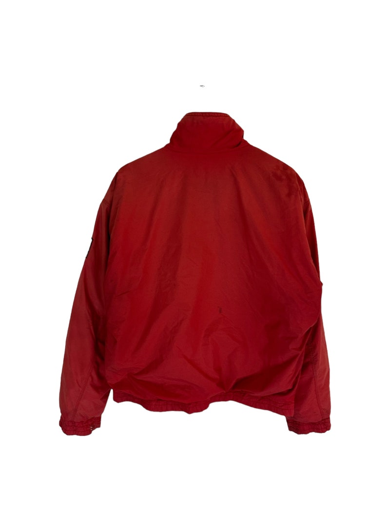 May include: A red jacket with a zip fastening and a high collar.