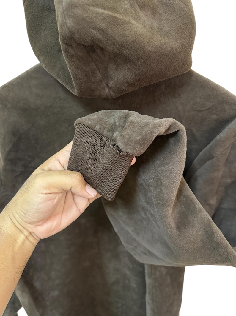 Puede incluir: Una sudadera con capucha marr&oacute;n de textura suave y peluda. La sudadera tiene una capucha con cord&oacute;n y un pu&ntilde;o de canal&eacute; en la manga.