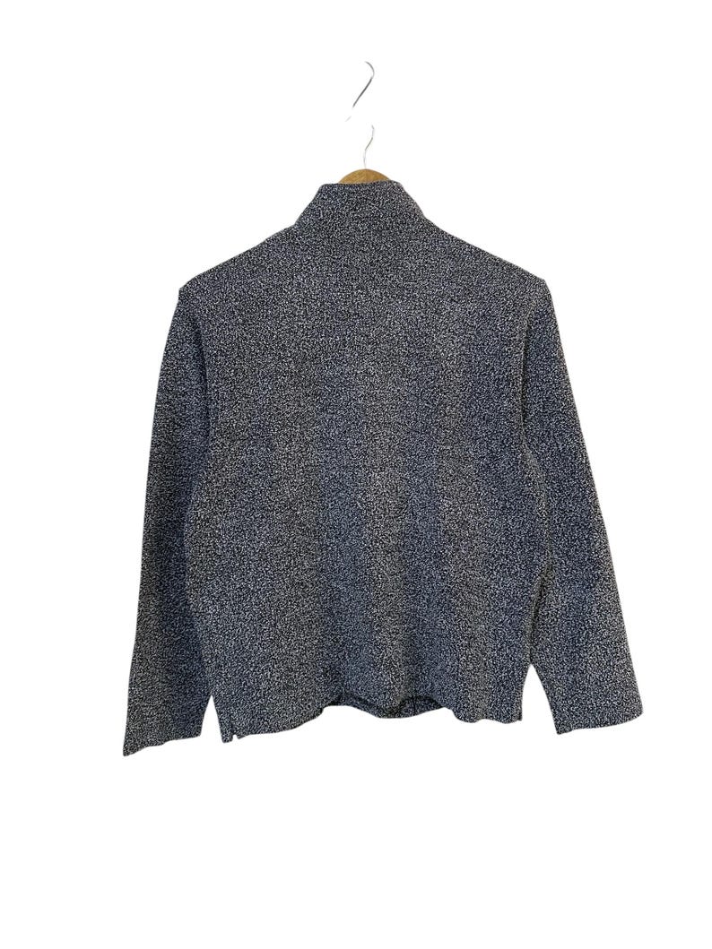 May include: A textured, dark gray sweater with a high collar and long sleeves. The fabric has a speckled pattern, and the garment is hanging on a wooden hanger against a white background. The sweater appears to be a casual, everyday wear item.