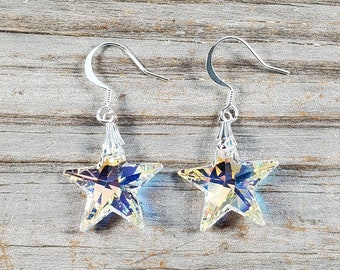 Può includere: Un paio di orecchini a forma di stella argentati con cristalli trasparenti iridescenti. Gli orecchini hanno una chiusura a gancio semplice.