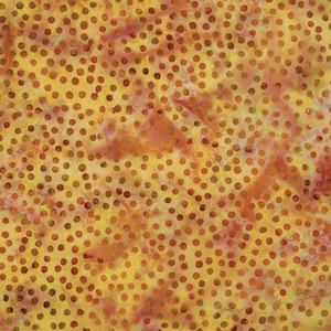 Könnte beinhalten: Nahaufnahme eines Stoffes mit einem gelb-orangen Polka-Dot-Muster. Die Punkte sind klein und gleichmäßig über die Oberfläche verteilt. Der Stoff hat ein gesprenkeltes Aussehen mit Farbvariationen.