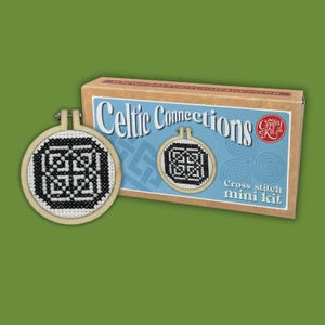 May include: A cross stitch mini kit titled Celtic Connections in a rectangular cardboard box with a light blue label, featuring a circular wooden embroidery hoop containing a black and white geometric cross stitch pattern on white fabric.