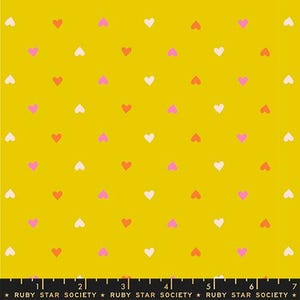 May include: Mustard yellow fabric with a repeating pattern of small hearts in white, pink, and red. The hearts are evenly spaced across the fabric. The text "RUBY STAR SOCIETY" is at the bottom.