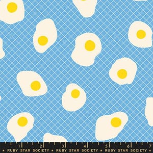 Puede incluir: Patrón repetido de huevos fritos sobre un fondo azul claro con una superposición de cuadrícula blanca. Los huevos tienen yemas amarillas y claras blanquecinas. El diseño es adecuado para tela o papel pintado.