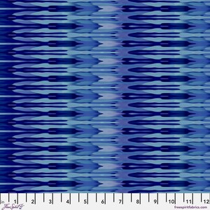 May include: A fabric swatch featuring a repeating horizontal ikat pattern in shades of navy, royal blue, and light blue. A white ruler at the bottom indicates a scale of 12 inches, with the text FreeSpirit and freespiritfabrics.com printed.