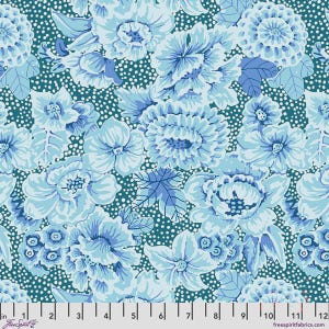 May include: A fabric featuring a repeating floral pattern in shades of light blue and white against a dark teal background with white polka dots. A ruler at the bottom shows measurements from 1 to 12 inches, with the text FreeSpirit Fabrics.