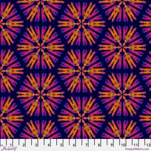 May include: A fabric pattern featuring a repeating kaleidoscope design of orange and magenta shapes on a dark navy blue background, with a white ruler at the bottom showing measurements from 0 to 12 inches for scale and reference.