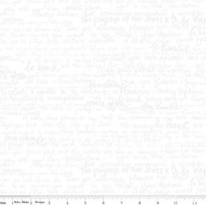 Op de afbeelding: Witte stof met handgeschreven tekst in lichtgrijs. De tekst bevat zinnen als 'be kind', 'love always' en 'the purpose of our lives is to be happy'. De stof wordt in inches gemeten.
