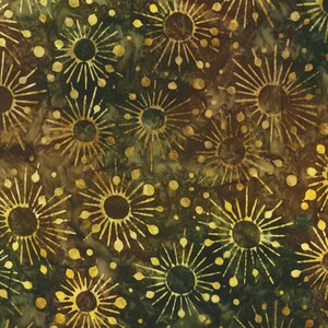 Op de afbeelding: Een stof met een herhaald patroon van gestileerde zonnestralen in goud- en bruintinten tegen een donkergroene en bruine gevlekte achtergrond. Het ontwerp heeft een batik-achtige uitstraling, met een textuur, organisch gevoel.