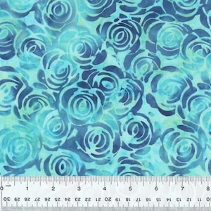 Puede incluir: Una tela azul turquesa con un patrón repetido de rosas estilizadas de color azul oscuro. La tela se mide con una regla en pulgadas.