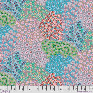 May include: A gray fabric featuring a dense, repeating floral pattern in shades of pink, light blue, bright green, and red. A white ruler is positioned along the bottom edge, showing measurements in inches from 0 to 12, with FreeSpirit branding.