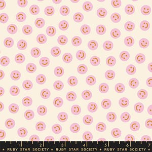 Puede incluir: Una tela crema con caras sonrientes rosas con sonrisas naranjas. La tela es de Ruby Star Society.