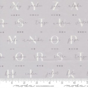 May include: Light gray fabric with a repeating pattern of alphabet letters and Morse code symbols. The letters are in a handwritten style, with the names of the letters written below. The fabric has a ruler along the bottom.