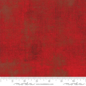 May include: Red fabric with a textured, distressed appearance. The fabric has a mottled effect with hints of brown and a ruler along the bottom edge. The fabric is suitable for quilting and other craft projects.