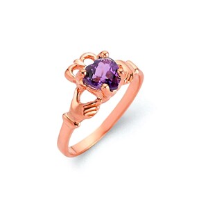 May include: A rose gold ring with a purple heart-shaped gemstone. The ring features a Celtic knot design with two hands holding the heart.
