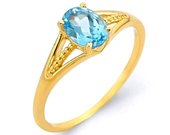 May include: A gold ring with a light blue oval gemstone. The ring has a delicate design with a split band and a beaded edge.