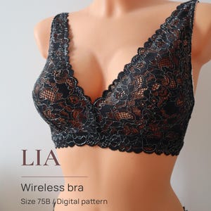 Puede incluir: Sujetador inalámbrico negro con una delicada capa de encaje. El sujetador presenta un diseño de cuello en V profundo y se muestra en un maniquí. El texto "LIA" y "Wireless bra" son visibles, junto con los detalles de talla y patrón.
