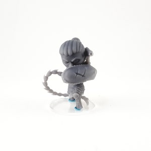 May include: A gray 3D printed miniature figurine of a character holding a shield and a weapon. The character has a chain wrapped around its arm. The figurine is standing on a clear plastic base.