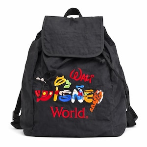 Puede incluir: Mochila negra con cierre de solapa y cordón. La mochila presenta un texto bordado colorido que dice "Walt Disney World" con un diseño de Mickey Mouse y un tigre. La mochila tiene correas ajustables.