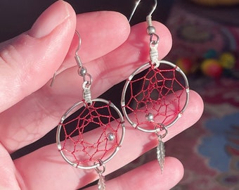 Silver dreamcatcher dangling earring with father detail and red thread