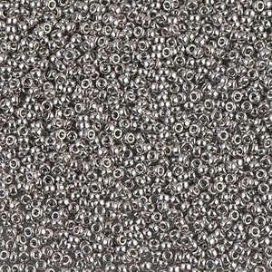 May include: A close-up view of a large quantity of silver seed beads. The beads are small and round, with a metallic sheen.