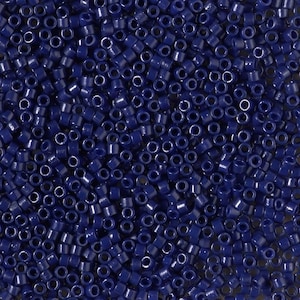 May include: A close-up view of a large quantity of small, dark blue round beads. The beads are arranged in a random pattern, creating a textured surface.