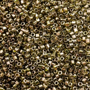 May include: A close-up image of a large quantity of small, gold-coloured, square-shaped beads.