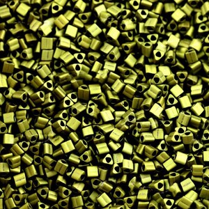 May include: A close-up image of a large quantity of small, metallic, green triangle-shaped beads. The beads have a matte finish and a small hole at the top.