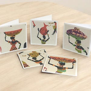 May include: Set of five greeting cards featuring colorful illustrations of women carrying various objects on their heads. The cards are white with a textured background and have a blank inside for writing.